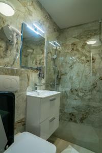 a bathroom with a white sink and a shower at SEE YOU Apartments in Niš +26 photos