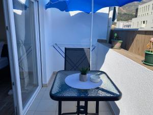a small table on a balcony with an umbrella at City Suites Budva in Budva