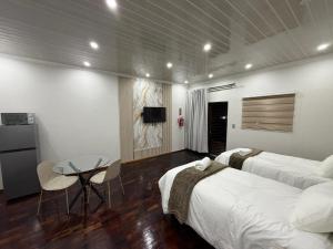 a bedroom with two beds and a table and a tv at Mehraz Guesthouse in Piet Retief +30 photos