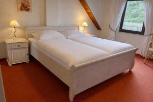 a large white bed in a bedroom with a window at Ferienhaus Knecht in Neef