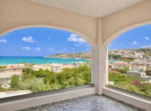 a room with large windows looking out at the ocean at Elysian Seaside Villa in Almyrida