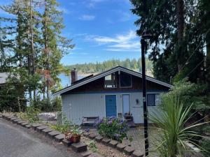 a small white house in the middle of trees at The Riptide Retreat in Shelton