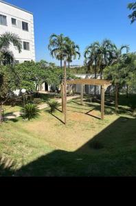 a park with palm trees and a building at Casa Bella in Catanduva