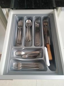 a tray filled with silver utensils in a drawer at Casa Bella in Catanduva