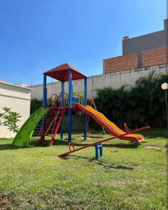a playground with a slide in the grass at Casa Bella in Catanduva