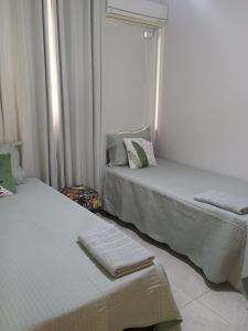 two beds sitting next to each other in a room at Casa Bella in Catanduva