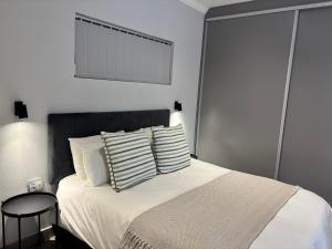 a bedroom with a bed with white sheets and pillows at Prospect Cottage in Walmer