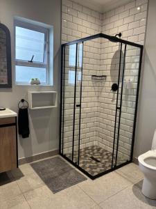 a shower with a glass door in a bathroom at Prospect Cottage in Walmer +6 photos