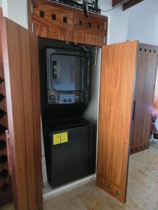 a kitchen with a tv and a small refrigerator at Condominio Dario 12 in Zihuatanejo