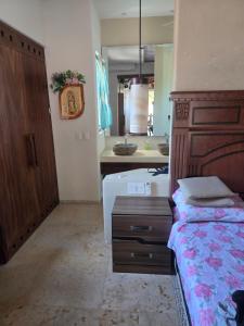 a bedroom with a bed and a bathroom with a sink at Condominio Dario 12 in Zihuatanejo