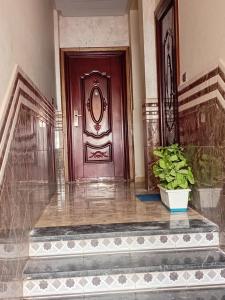 a purple door in a building with a potted plant at Sidi Rahal Playa beach in Casablanca