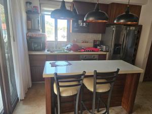 a kitchen with a counter and two chairs at a table at Condominio Dario 12 in Zihuatanejo +3 photos