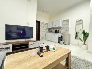 a living room with a tv and a wooden table at راكة سويت الخبر للشقق الفندقية المخدومة in Al Khobar +108 photos