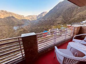 a balcony with chairs and a view of a mountain at Most Awarded Property In Mussoorie in Mussoorie