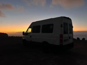 a white van parked in a field at sunset at Furgocamper in Lanzarote