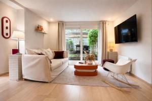 a living room with a white couch and a table at Acmé Appartement 200 m du lac d'Annecy in Angon