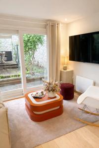 a living room with a table and a large window at Acmé Appartement 200 m du lac d'Annecy in Angon +8 photos