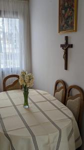 a dining room table with a vase of flowers on it at Međugorje Quit Hideaway in Botići +8 photos