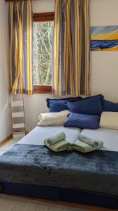 a bed with blue pillows and a window at Međugorje Quit Hideaway in Botići