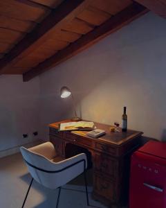 a desk with a chair and a bottle of wine at La Torre Masana in Vigostano