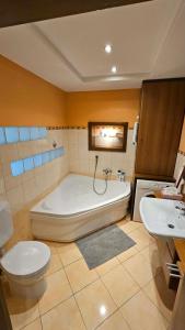 a bathroom with a tub and a toilet and a sink at Mézi Lazy in Gyenesdiás