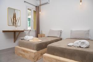 two beds in a room with a hat and a mirror at SeaView City in Samos +28 photos