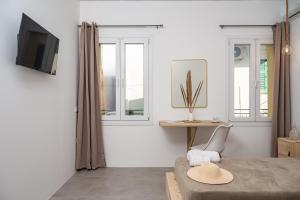 a room with a bed and a table and windows at SeaView City in Samos