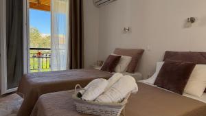 a bedroom with two beds and a window with a view at Marili Apartments in Roda