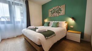 a bedroom with a large bed with a green wall at San Martì Casa Vacanze in Piazza Brembana