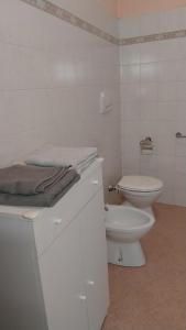 a white bathroom with a toilet and a sink at Tenuta Rio del Sole-Camera doppia in Albairate +4 photos