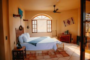 a bedroom with a white bed and a window at Casa Ceiba Huatulco - Adults Only in Santa Cruz Huatulco