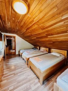three beds in a room with a wooden ceiling at Chata Mir in Dolní Bečva