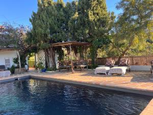 a swimming pool with a table and chairs next to a house at Boutique Finca Stay in Nature in Mijas