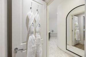 a white dress hanging on a door in a bathroom at Buckingham & Lloyds Knightsbridge in London +93 photos