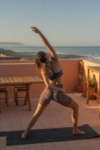 a woman doing a yoga pose on a rooftop at Flooka Surf Yoga in Imsouane