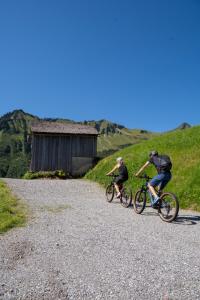 two people riding bikes down a gravel road at Berghaus Schäfer in Faschina