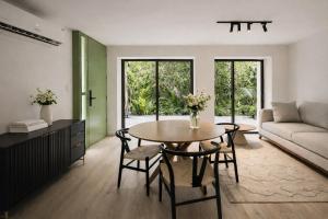 a living room with a table and chairs and a couch at Garden Atelier - Private Cenote & Steps from the Beach in Tulum