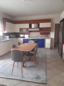 a kitchen with a wooden table and chairs at Kings and Queens 1 in Larisa
