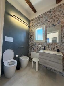a bathroom with a toilet and a sink and a mirror at Scopello Guidaloca Villas in Scopello +94 photos