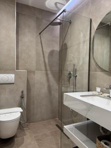 a bathroom with a shower and a sink and a toilet at Hotel Veizi in Himare