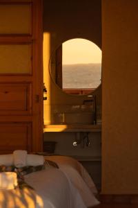 a bedroom with a large mirror and a bed at Flooka Surf Yoga in Imsouane