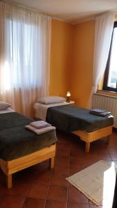 two beds sitting in a room with a window at Tenuta Rio del Sole-Appartamento in Albairate