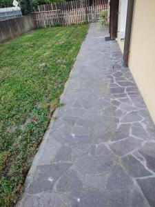a stone walkway next to a yard withgrass at Rifugio Sereno de Tajo in Taglio di Po