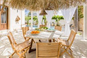 a table and chairs on a patio with a bowl of fruit at Villa Raphael in Avola