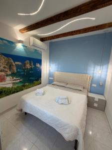 a bedroom with a large bed with a painting on the wall at Scopello Guidaloca Villas in Scopello