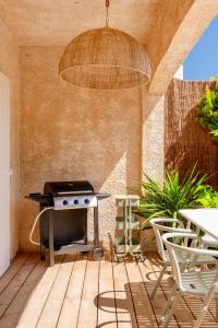 a patio with a grill and a table and chairs at T2 Haut de gamme avec jardin privé - 50m du port Miramar in La Londe-les-Maures