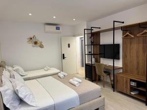 a bedroom with a bed and a desk and a television at Hotel Veizi in Himare