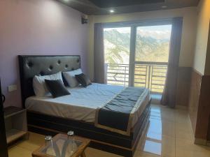 a bedroom with a large bed with a large window at Laxman Homestay in Sarāhan