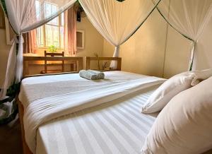 a bedroom with a bed with two pillows on it at Villa Katwe in Masaka