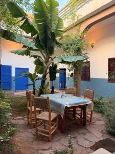 a table with chairs and a tree in a yard at RiadTiznitSouss Votre oasis privée à Tiznit in Tiznit